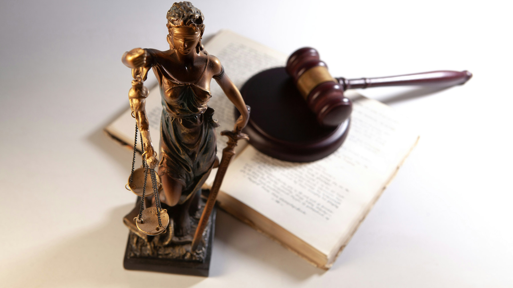 Figura de la justicia con balanza, martillo y libro en un entorno legal, representando servicios notariales y soluciones jurídicas en Irapuato.